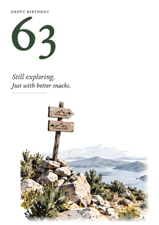A wooden trail sign on a rocky lookout above a lake and mountains, beneath a green 63
